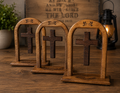 Three handcrafted floating wooden Christian crosses displayed on a rustic tabletop